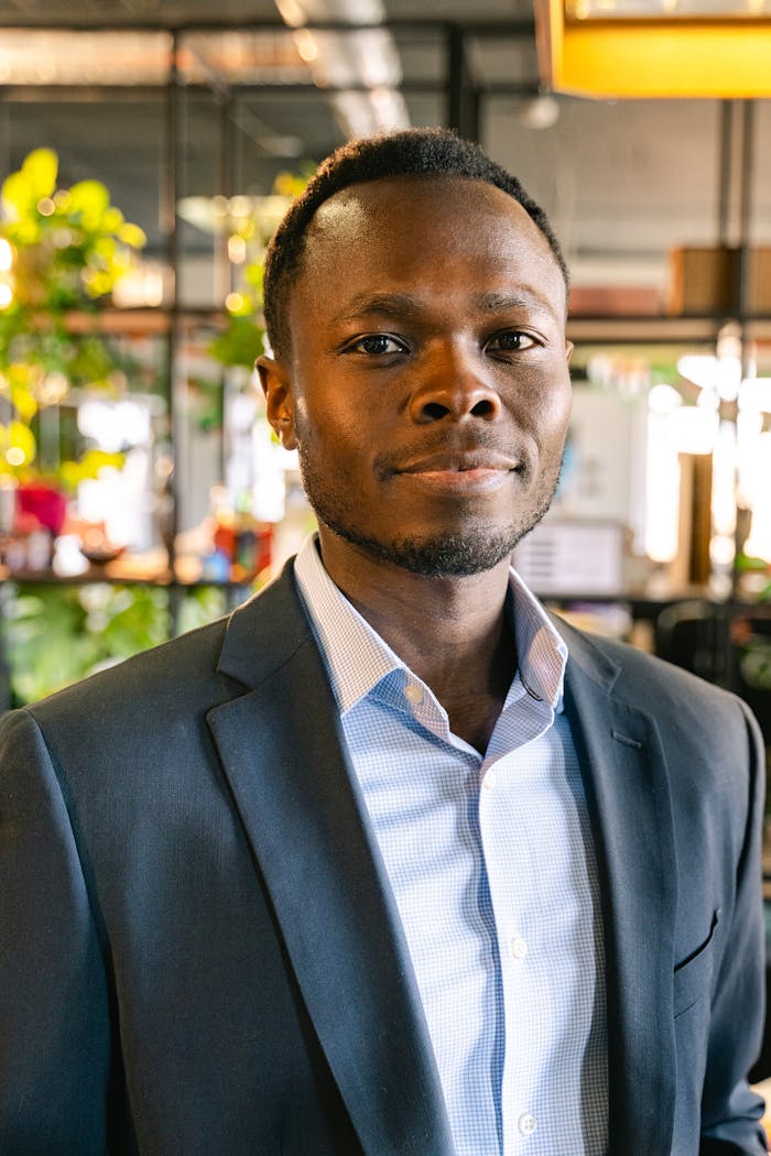 services-04 Portrait of a smiling man in a elegant black suit, indoors.